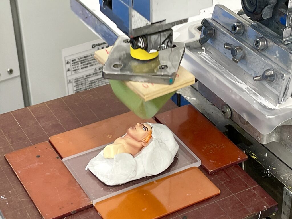 印刷工程：フィギュアの目にタンポ印刷している様子