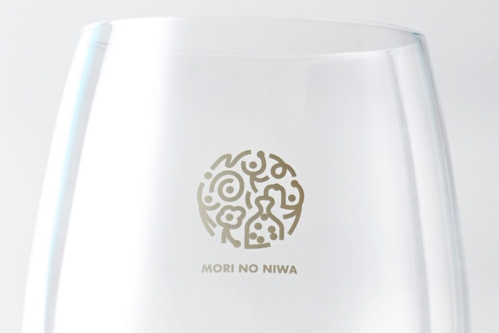 グラスへの単色印刷事例：白インクや単色のインクを使用したロゴ印刷。飲み物を注いだ際にロゴが鮮明に浮かび上がる、王道のデザイン。