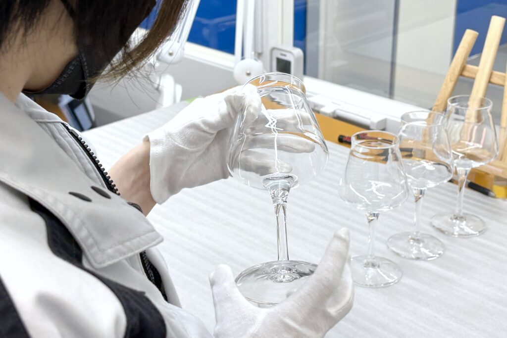 小ロットのグラス印刷工程。お持ち込みされたグラスに傷や割れ、カケがないか、検品している様子。