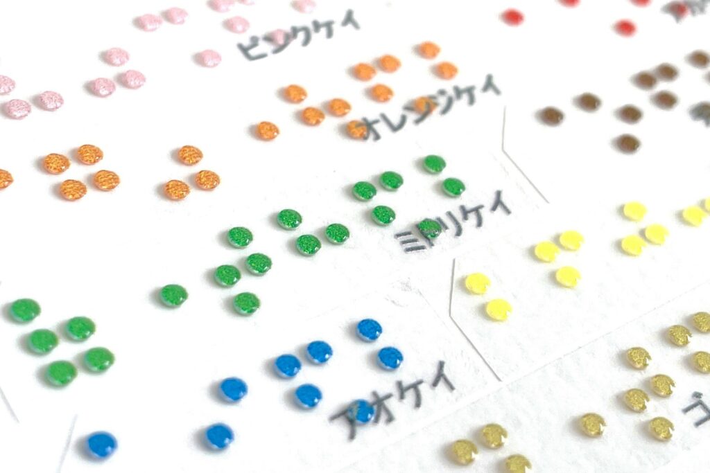 点字に色を付けて目の煮える人にも点字の存在をアピールできる「カラー点字」
